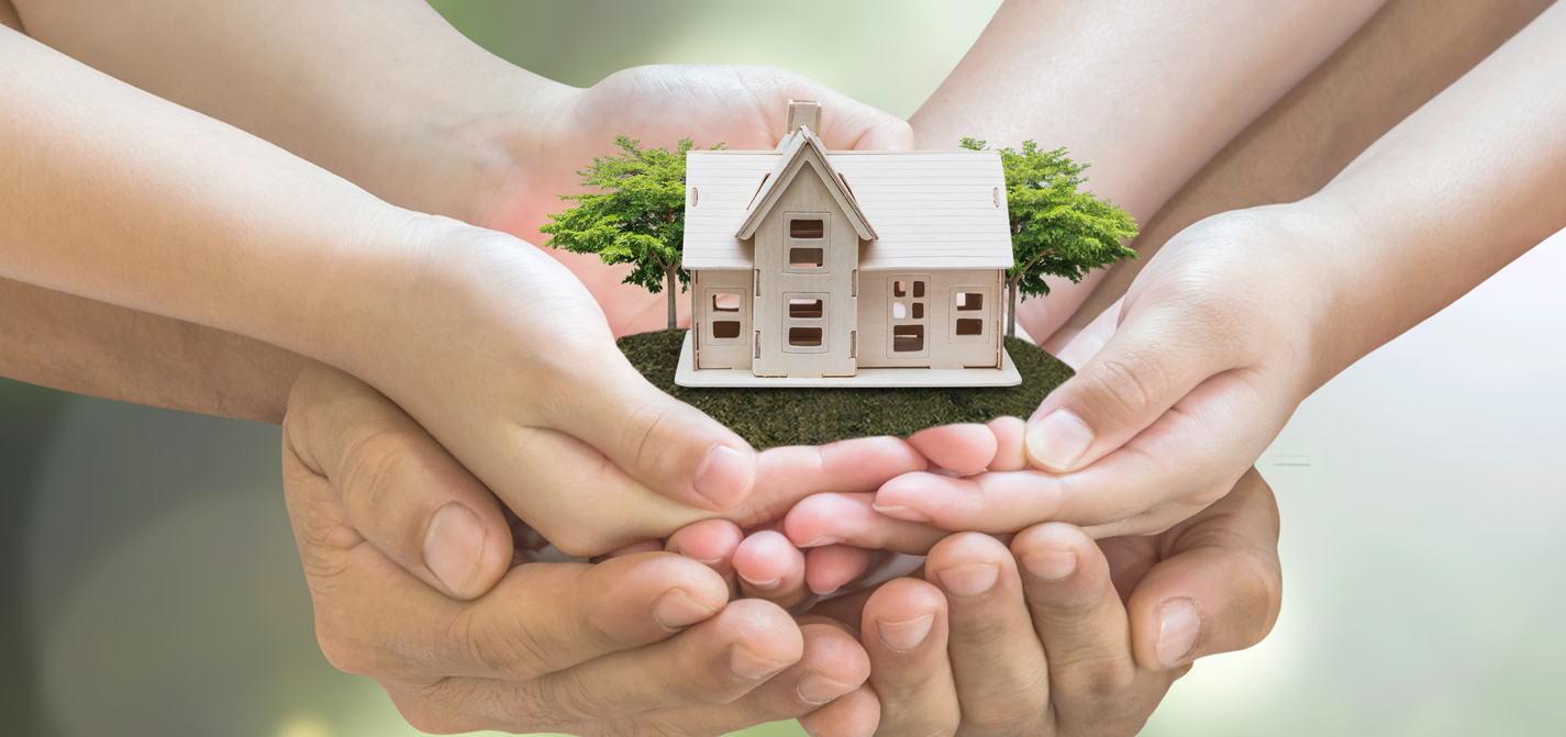 Hands holding a small model home