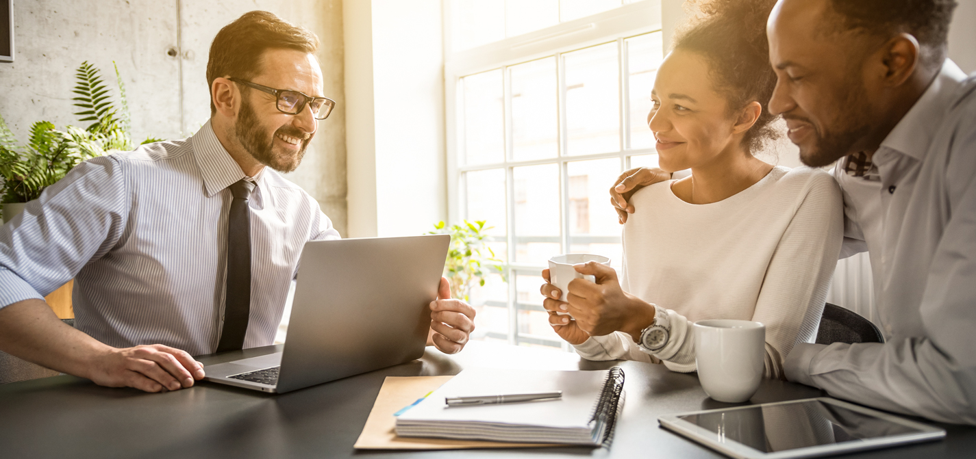 A loan officer reviewing mortgage options with a couple at a table